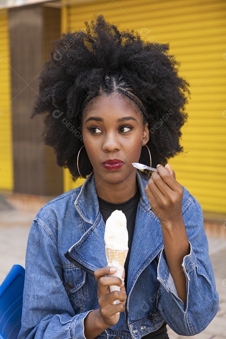 Linda mulher jovem negra cabelo afro cacheado tomando sorvete
