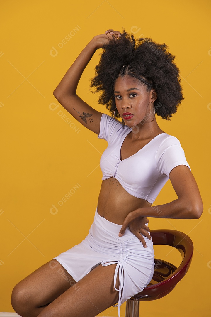 Linda mulher jovem negra cabelo afro cacheado pousando para fotografias