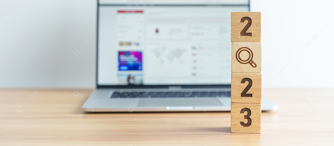 Bloco de 2023 com ícone de lupa contra o fundo do laptop.