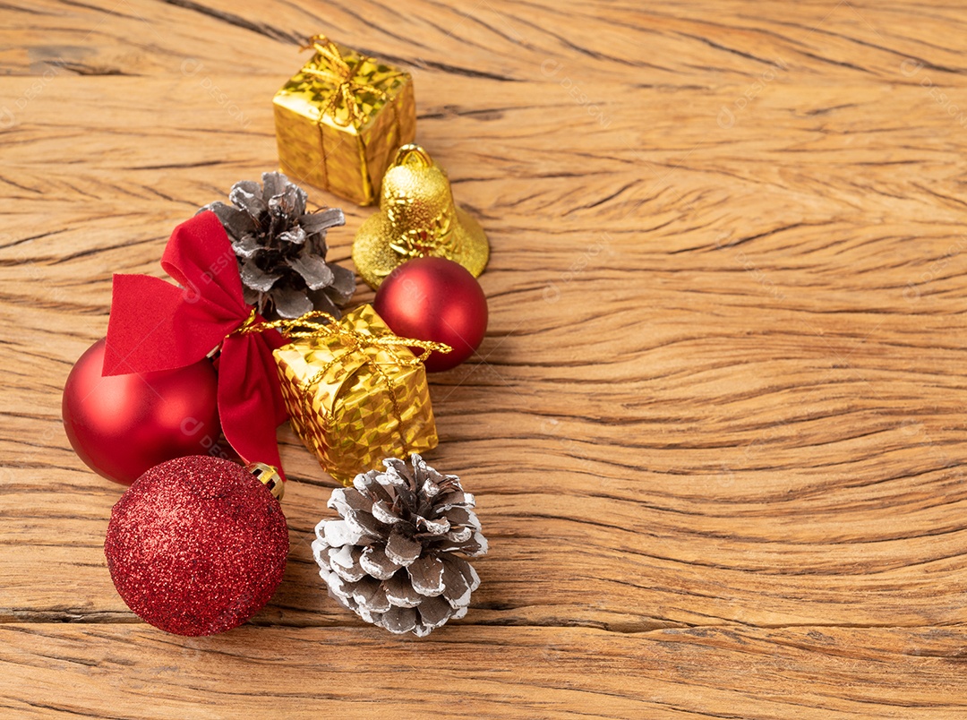 Caixas de presente, pinhas, bolas de natal e arco sobre mesa de madeira