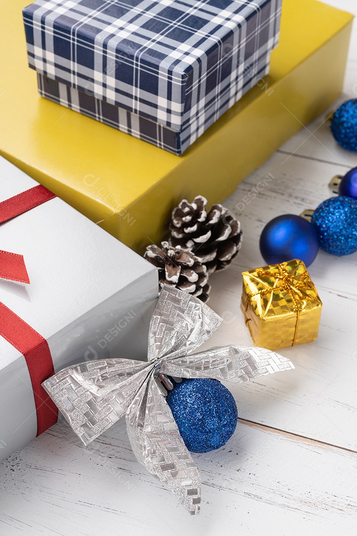 Caixa de presente, bolas de natal e arco sobre a mesa de madeira.