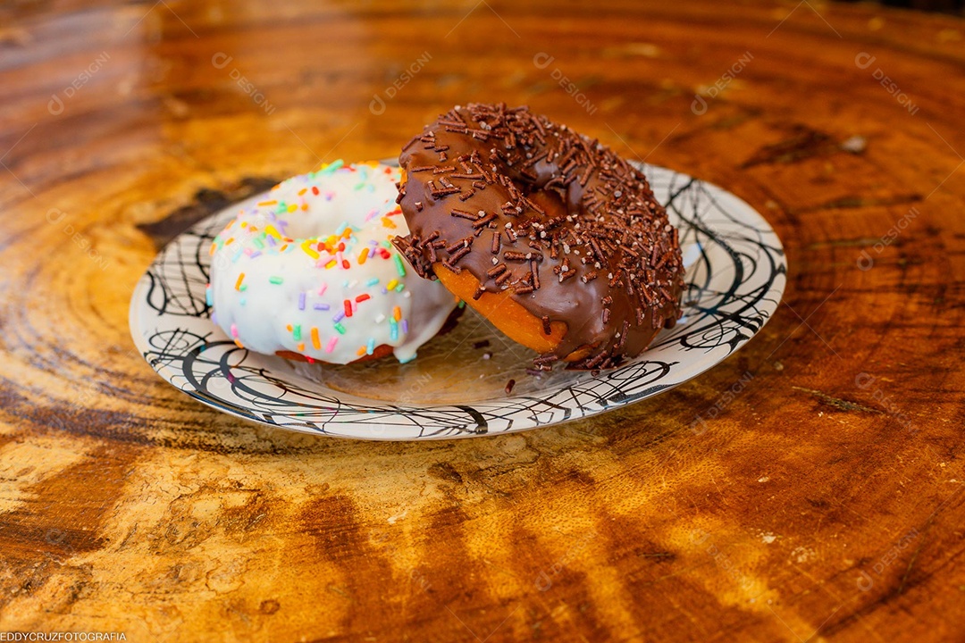 Dois donuts em um prato sobre uma mesa de madeira