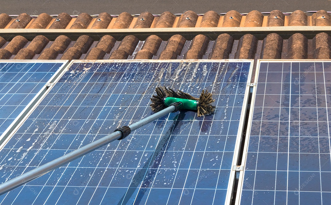 Trabalhador solar limpando painéis fotovoltaicos com pincel e água. Limpeza fotovoltaica, antes e depois. Espaço para texto.