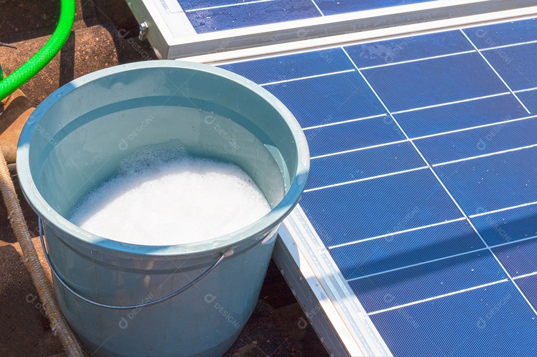 Trabalhador solar limpando painéis fotovoltaicos com pincel e água. Limpeza fotovoltaica, antes e depois. Espaço para texto.