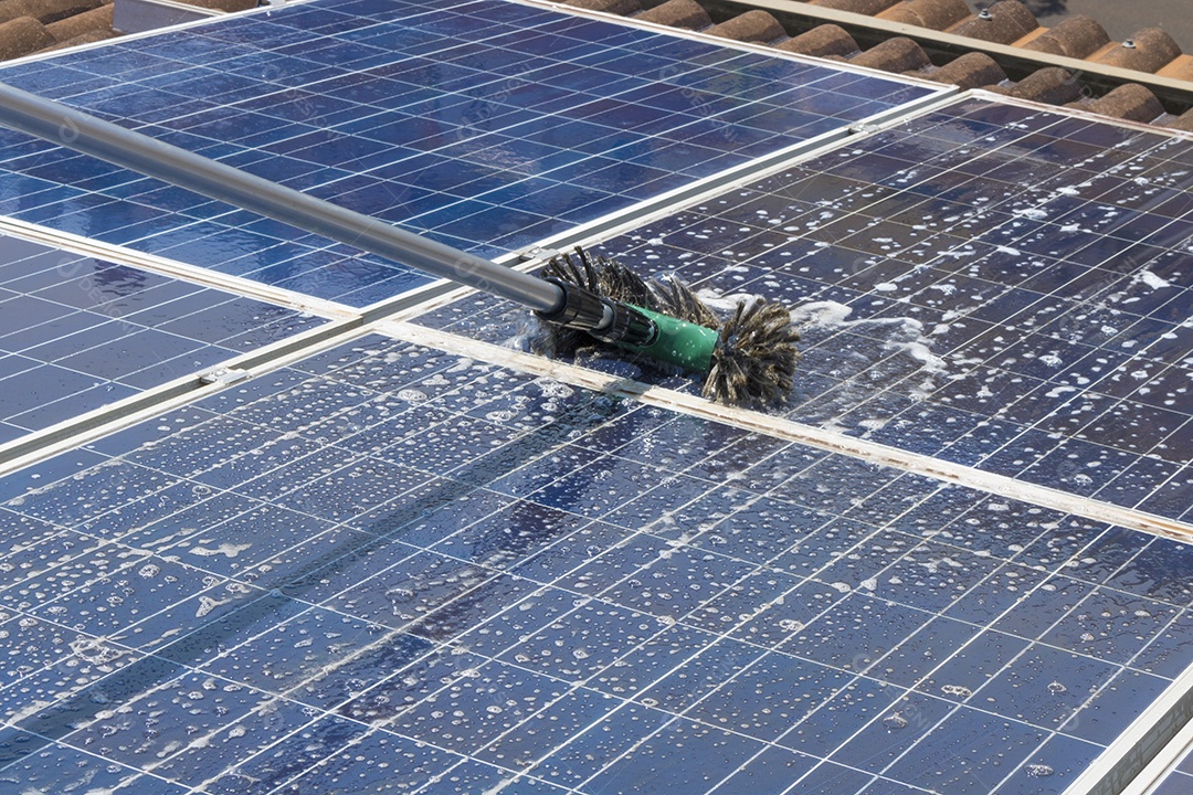 Trabalhador solar limpando painéis fotovoltaicos com pincel e água. Limpeza fotovoltaica, antes e depois. Espaço para texto.