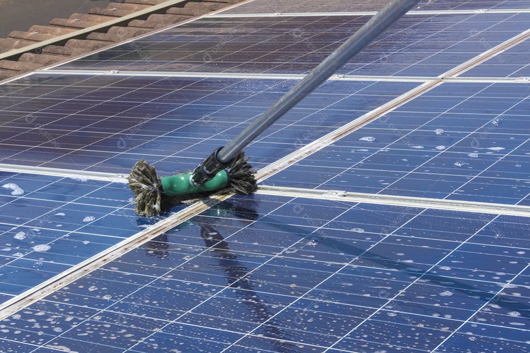 Trabalhador solar limpando painéis fotovoltaicos com pincel e água. Limpeza fotovoltaica, antes e depois. Espaço para texto.
