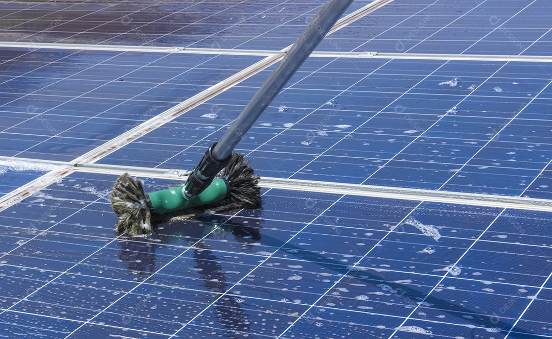 Trabalhador solar limpando painéis fotovoltaicos com pincel e água. Limpeza fotovoltaica, antes e depois. Espaço para texto.