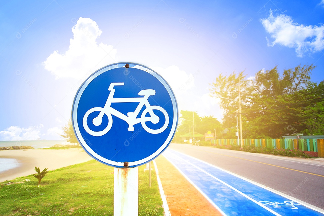 Sinal de aviso azul da ciclovia na praia com luz solar