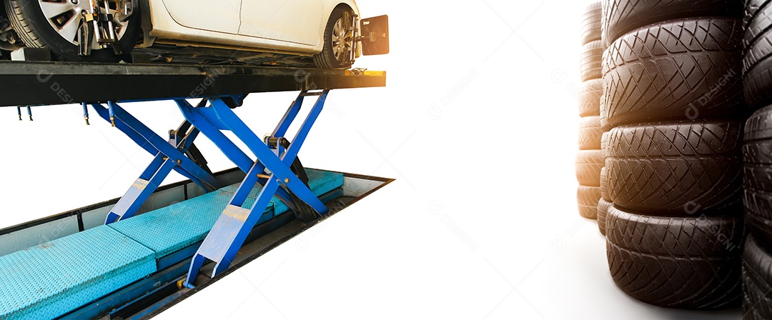 Uma pilha de pneu de automóvel e carro branco no elevador de carro hidráulico