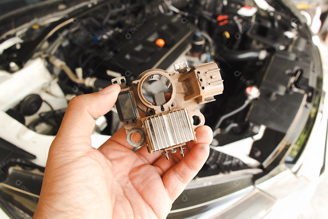 Alternador automotivo do retificador antigo segurado pela mão do mecânico de automóveis