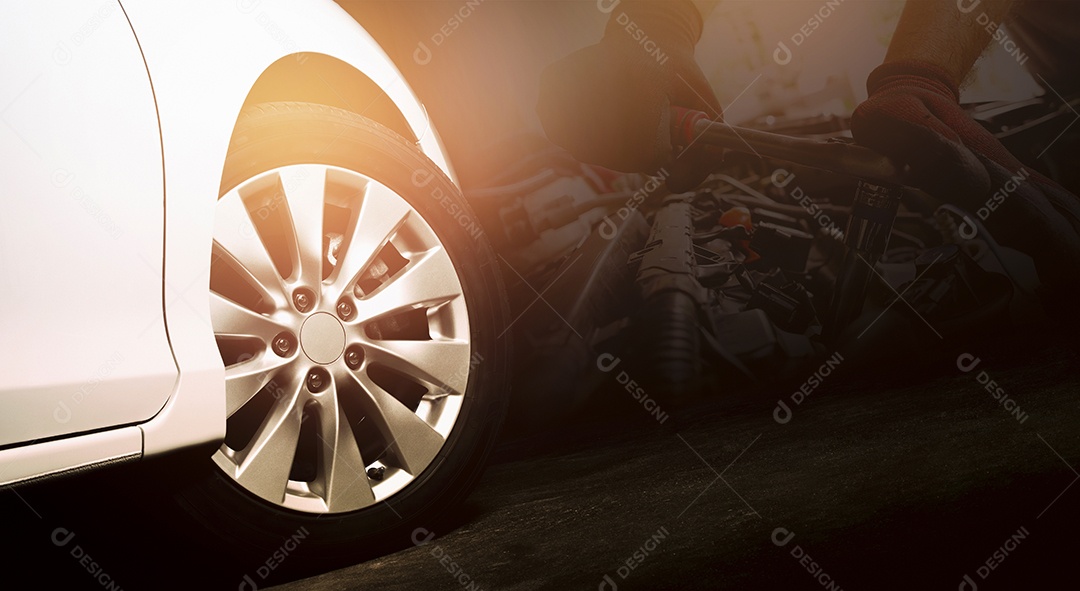 As rodas de liga leve do carro branco estão girando na estrada de cimento