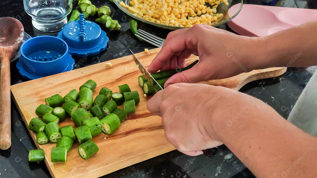 Mãos cortando quiabo legumes tabua madeira