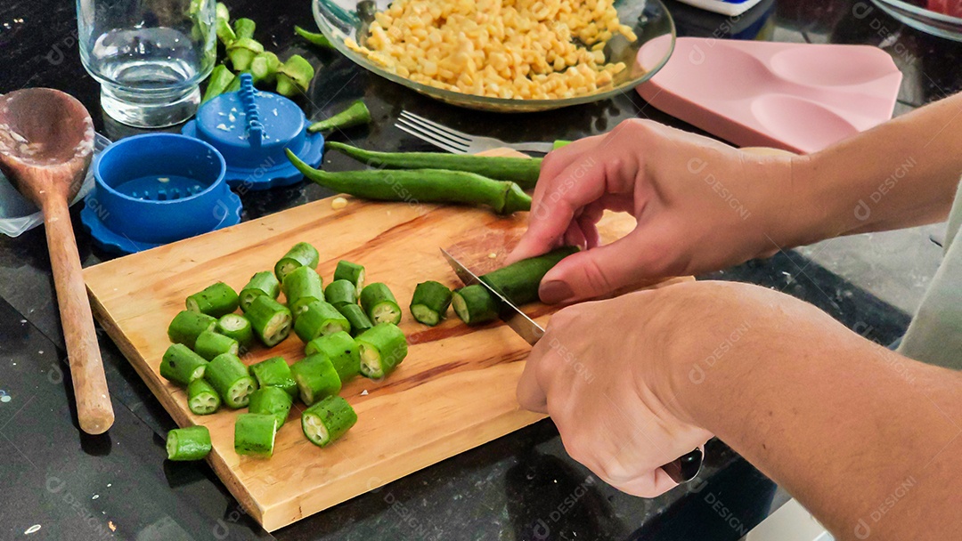 Mãos cortando quiabo legumes tabua madeira