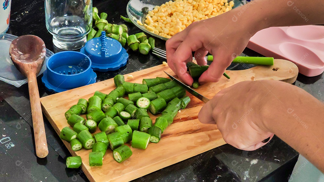 Mãos cortando quiabo legumes tabua madeira