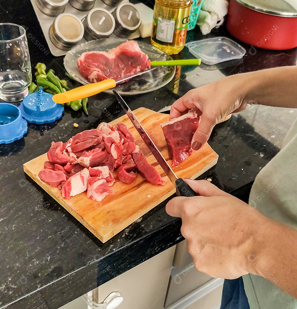 Mãos cortando carne crua vermelha tabua madeira