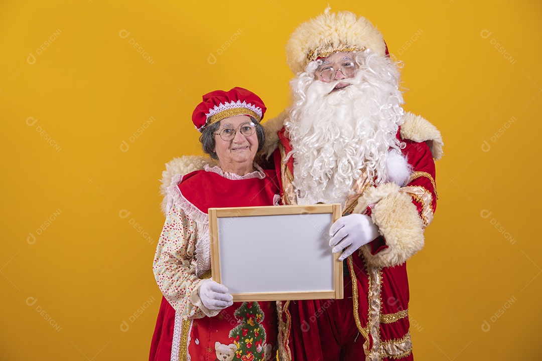 Lindo Casal Papai Noel ao lado de Mamãe Noel sobre fundo isolado amarelo