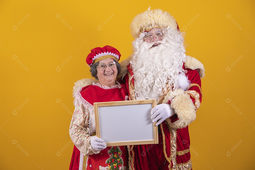 Lindo Casal Papai Noel ao lado de Mamãe Noel sobre fundo isolado amarelo