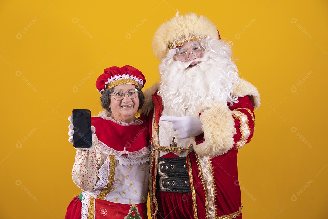 Lindo Casal Papai Noel ao lado de Mamãe Noel sobre fundo isolado amarelo