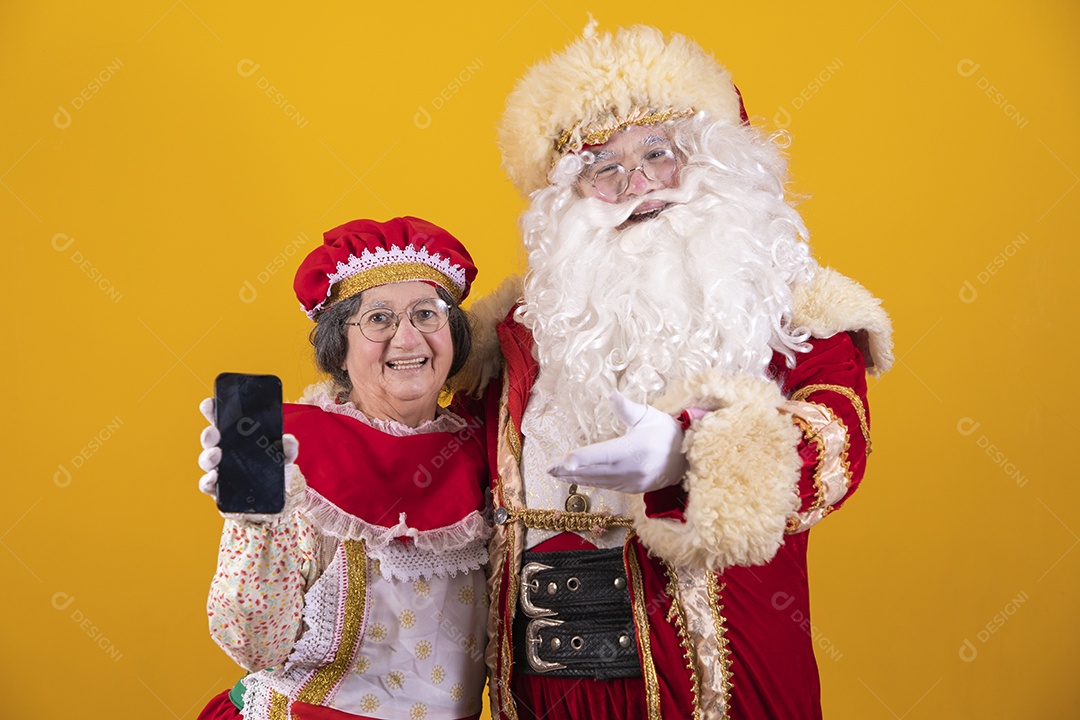 Lindo Casal Papai Noel ao lado de Mamãe Noel sobre fundo isolado amarelo