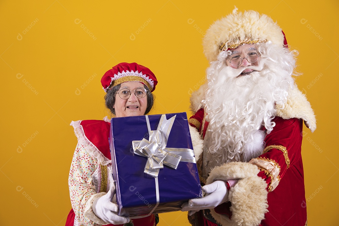 Lindo Casal Papai Noel ao lado de Mamãe Noel sobre fundo isolado amarelo