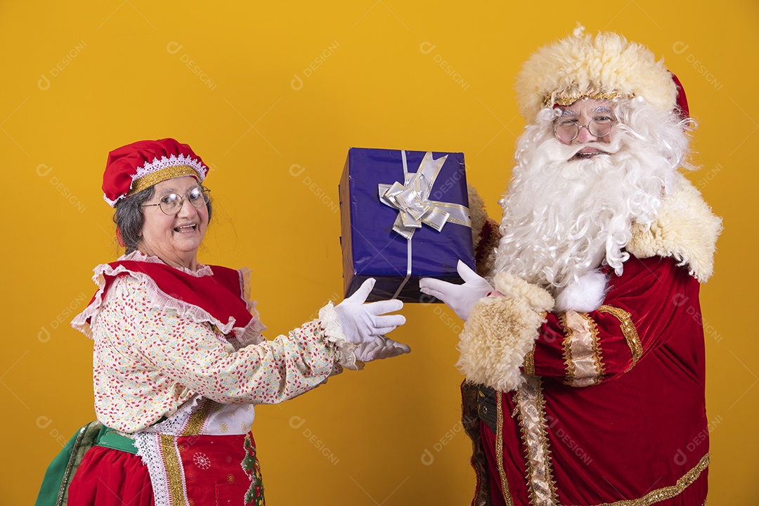 Lindo Casal Papai Noel ao lado de Mamãe Noel sobre fundo isolado amarelo