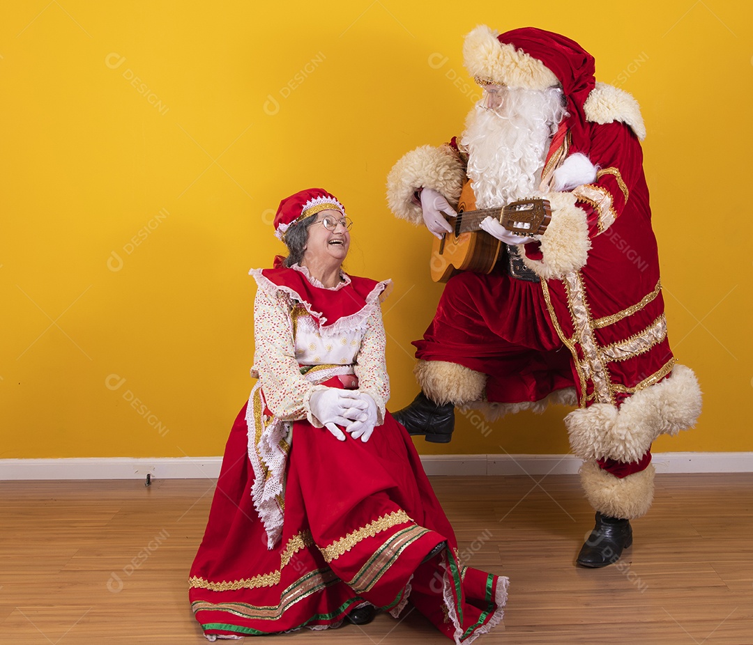 Papai Noel ao lado de Mamãe Noel sobre fundo isolado amarelo