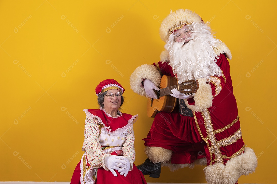 Papai Noel ao lado de Mamãe Noel sobre fundo isolado amarelo