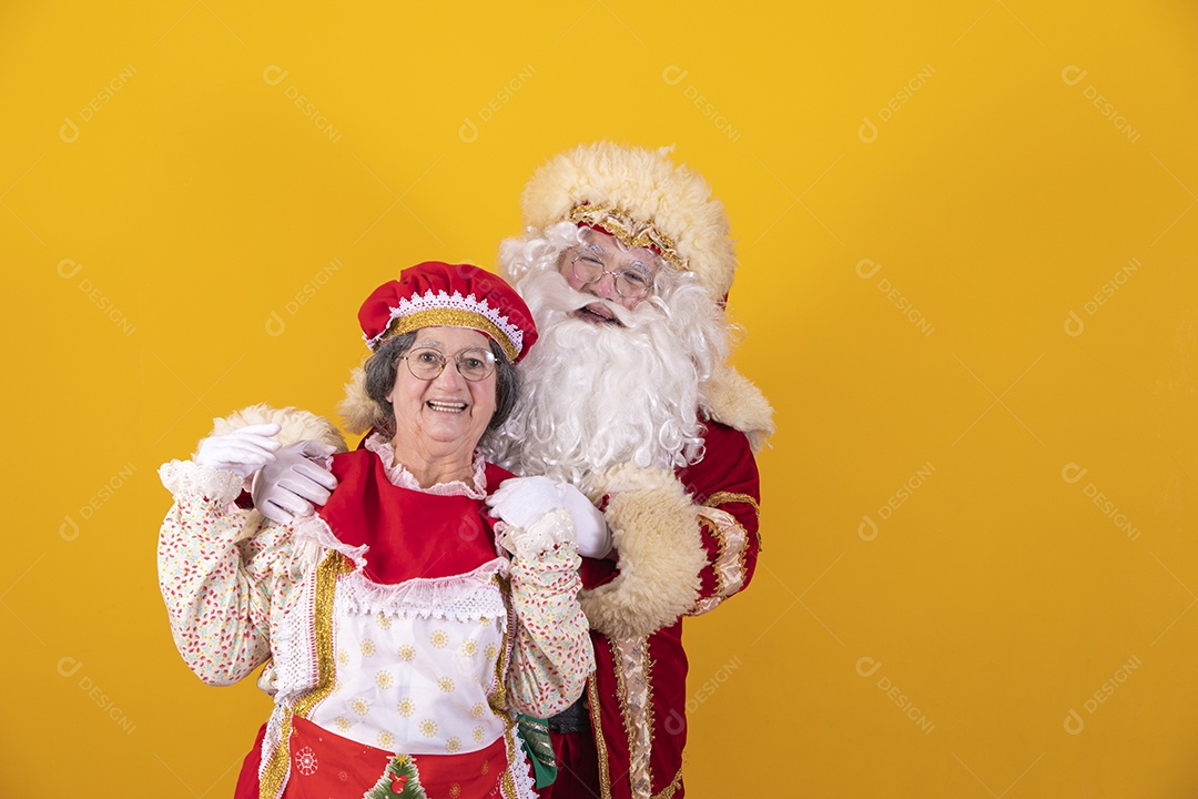 Papai Noel ao lado de Mamãe Noel sobre fundo isolado amarelo