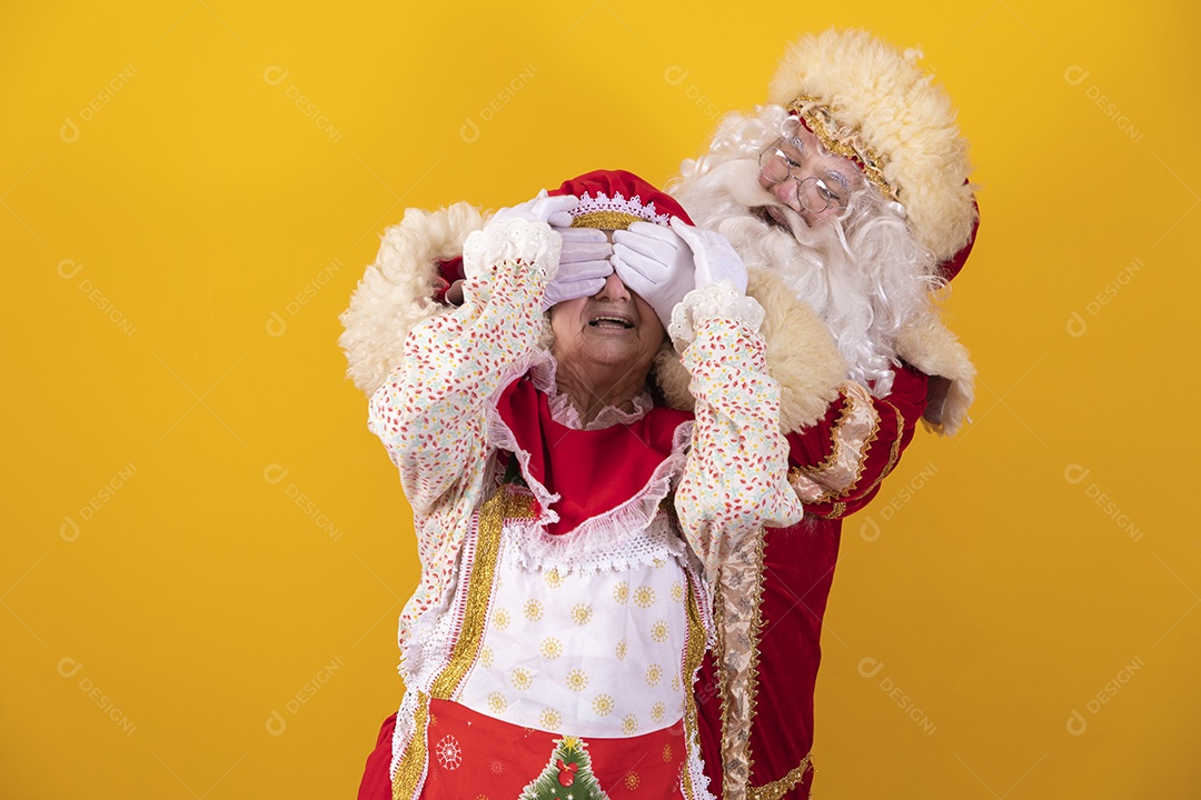 Papai Noel ao lado de Mamãe Noel sobre fundo isolado amarelo