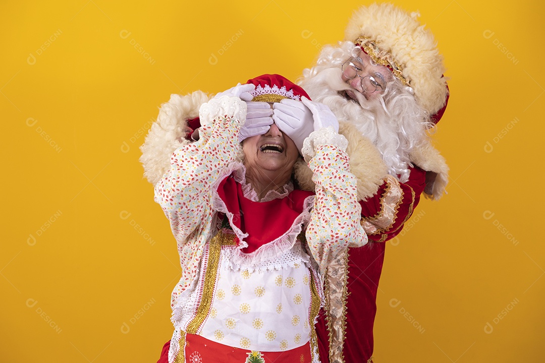 Papai Noel ao lado de Mamãe Noel sobre fundo isolado amarelo