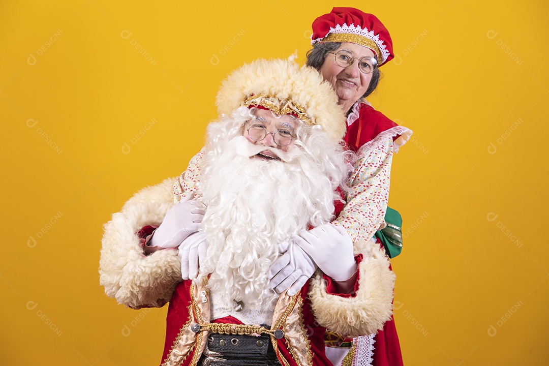 Papai Noel ao lado de Mamãe Noel sobre fundo isolado amarelo
