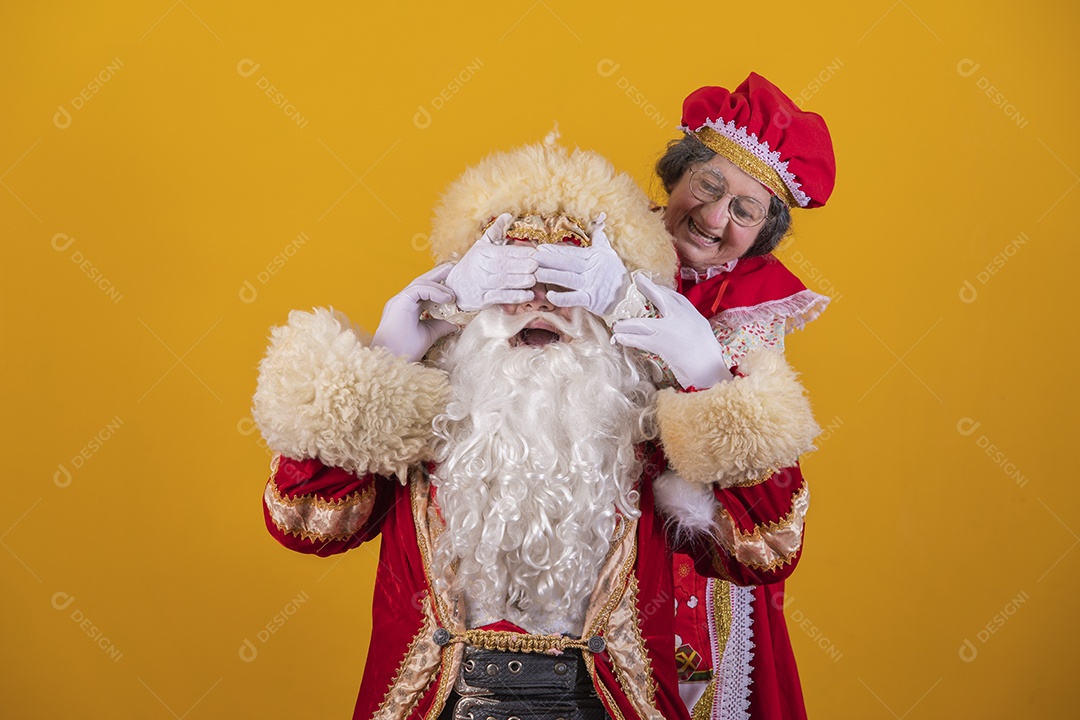 Papai Noel ao lado de Mamãe Noel sobre fundo isolado amarelo