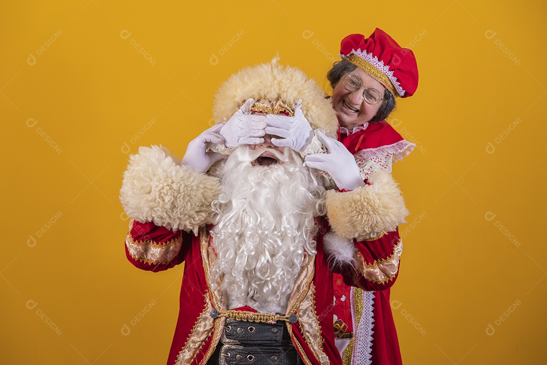 Papai Noel ao lado de Mamãe Noel sobre fundo isolado amarelo