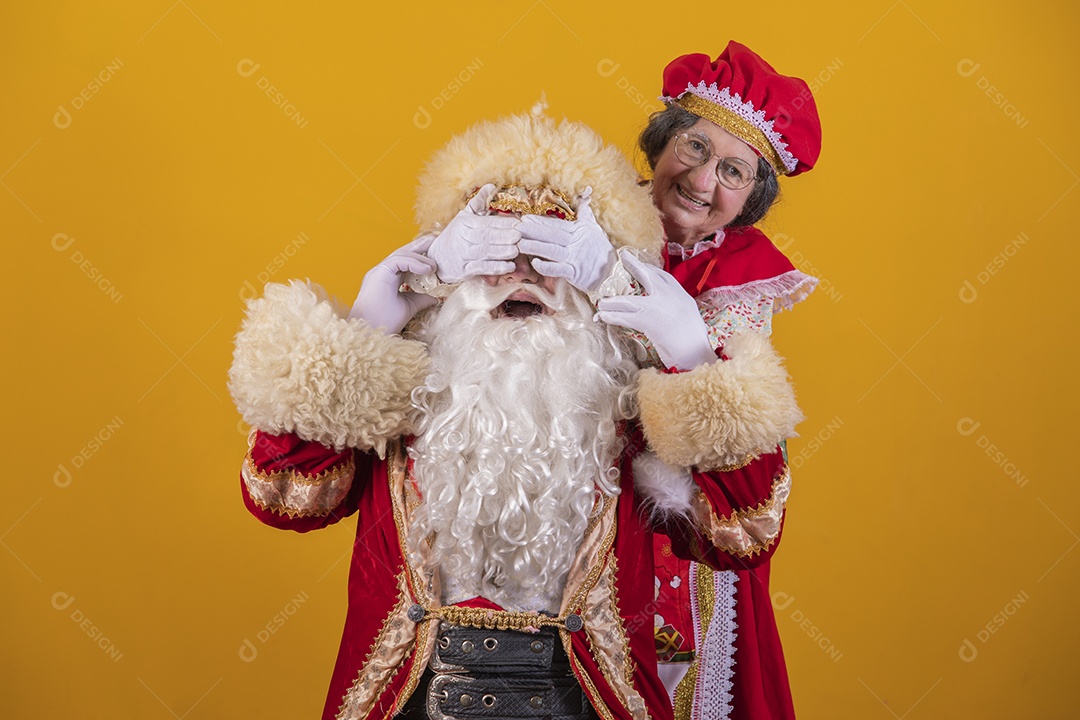 Papai Noel ao lado de Mamãe Noel sobre fundo isolado amarelo