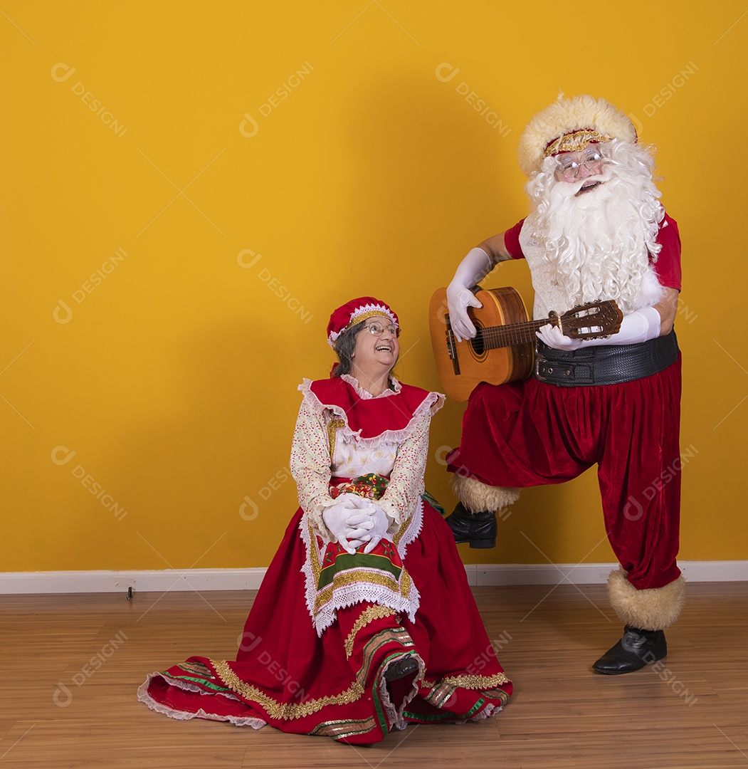 Papai Noel ao lado de Mamãe Noel sobre fundo isolado amarelo