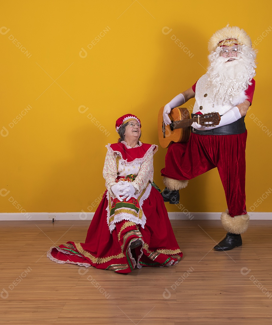 Papai Noel ao lado de Mamãe Noel sobre fundo isolado amarelo