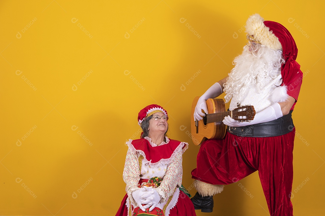 Papai Noel ao lado de Mamãe Noel sobre fundo isolado amarelo
