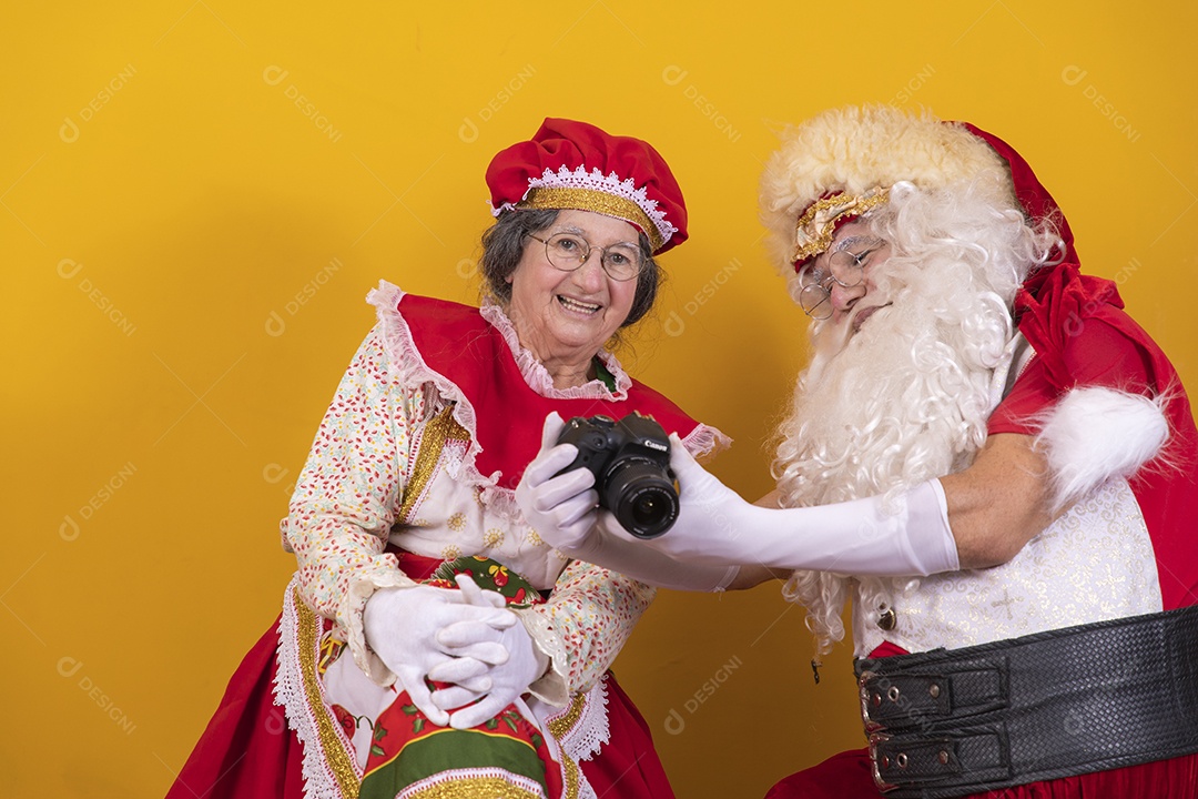Papai Noel ao lado de Mamãe Noel sobre fundo isolado amarelo