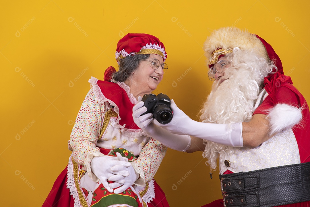 Papai Noel ao lado de Mamãe Noel sobre fundo isolado amarelo