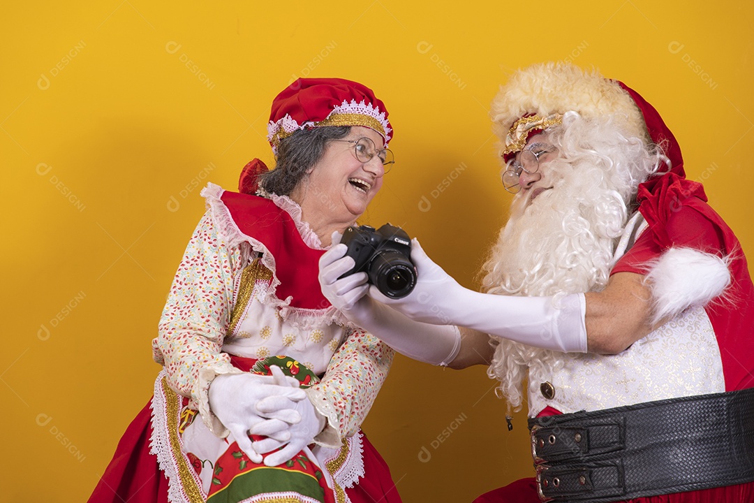 Papai Noel ao lado de Mamãe Noel sobre fundo isolado amarelo