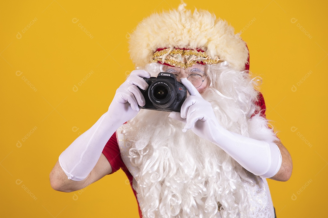 Papai Noel segurando câmera sobre fundo isolado amarelo