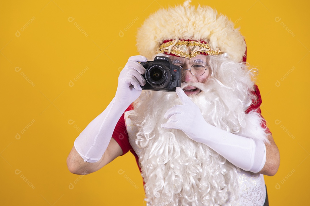 Papai Noel segurando câmera sobre fundo isolado amarelo