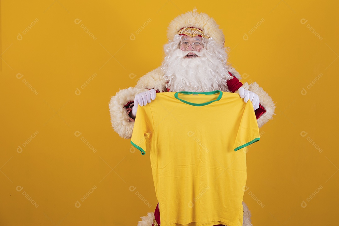 Papai Noel feliz segurando camiseta do brasil torcedor fundo isolado amarelo