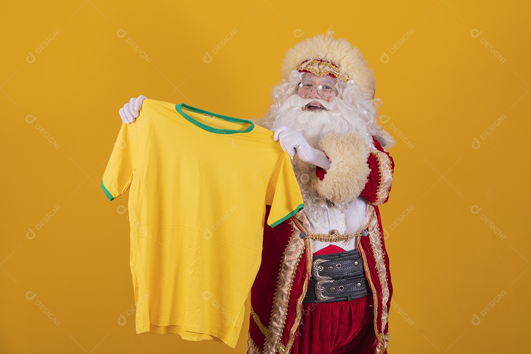 Papai Noel feliz segurando camiseta do brasil torcedor fundo isolado amarelo