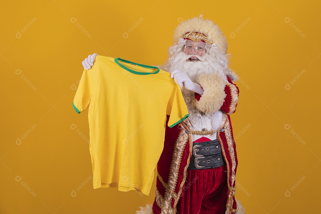 Papai Noel feliz segurando camiseta do brasil torcedor fundo isolado amarelo