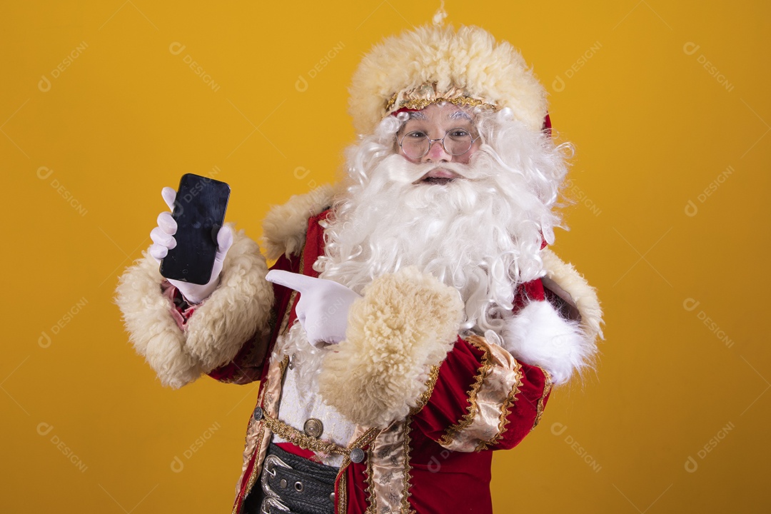 Papai Noel feliz e sorridente segurando celular smartphone Feliz Natal