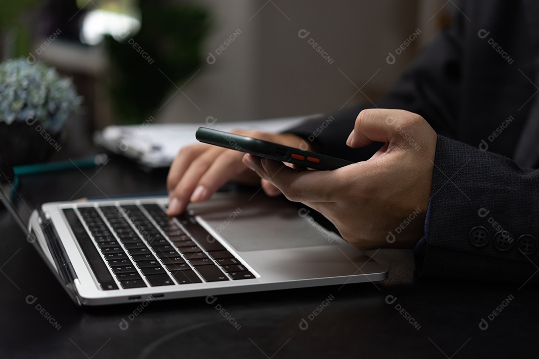 Homem com smartphone móvel em suas mãos e usando teclado portátil