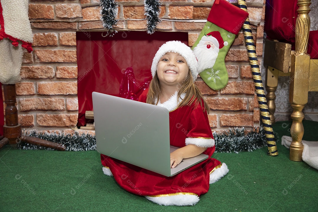Linda menina fantasiada de Papai Noel usando touca Feliz Natal