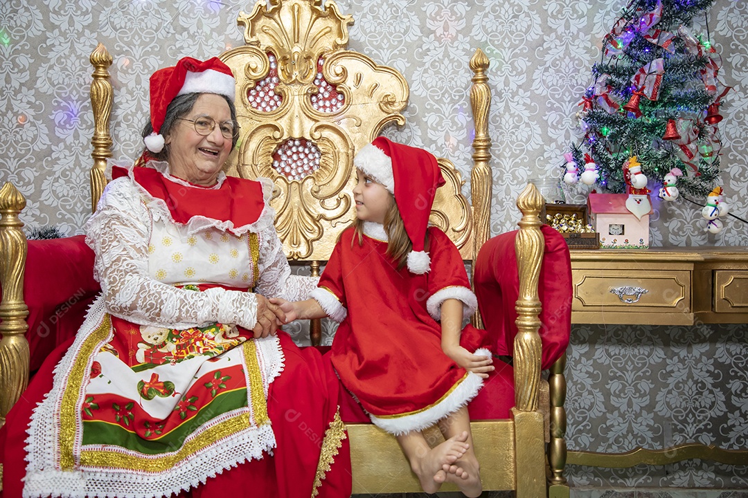 Vó tirando fotografia com sua neta celebrando natal ceia