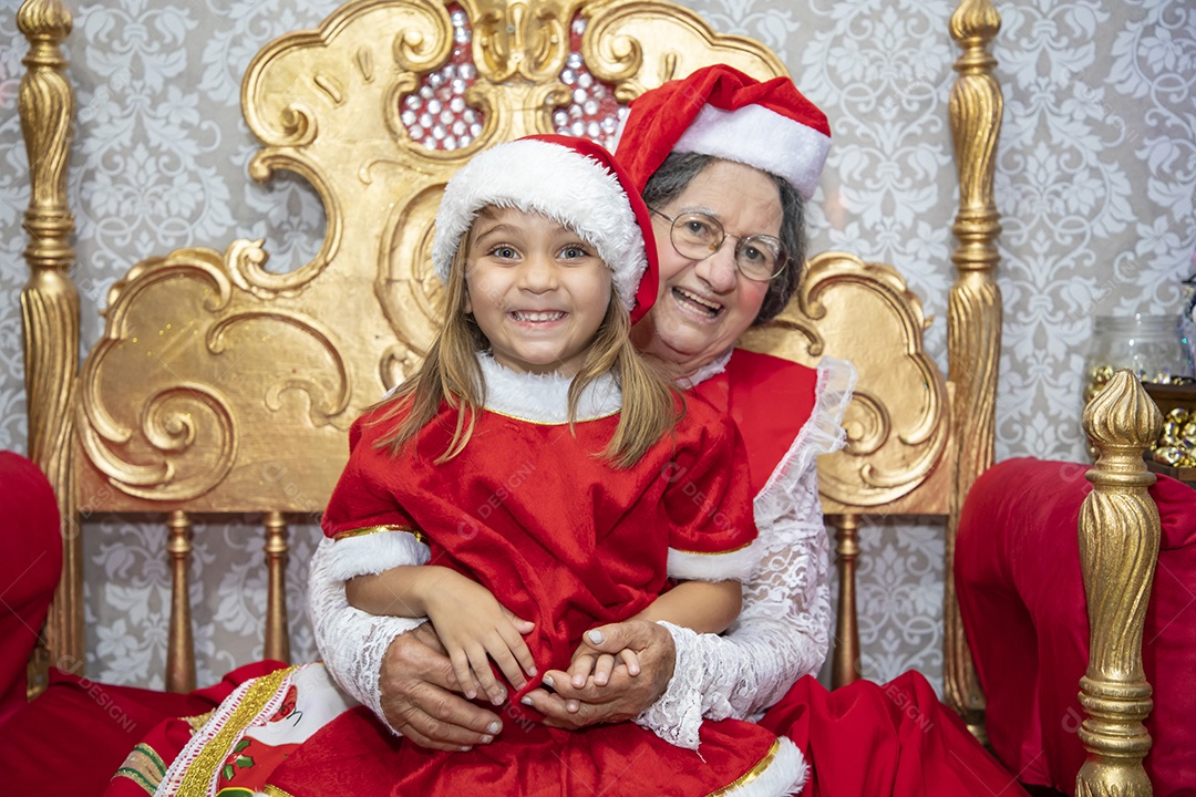 Vó tirando fotografia com sua neta celebrando natal ceia